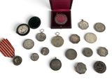 une boîte de pièces d'argent et une médaille posées sur une surface blanche