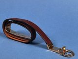 leather dog leash with a caramel colored handle on a blue background