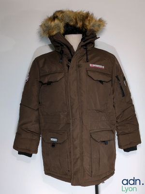 La veste est marron et possède une capuche doublée de fourrure.