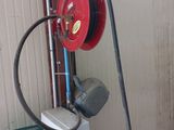 a red fire hose attached to a water heater in a garage