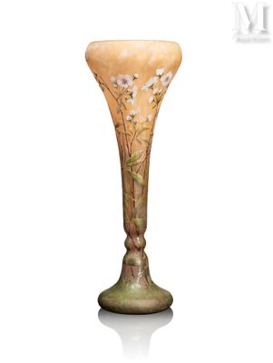 un vase orné de fleurs, posé sur une surface blanche