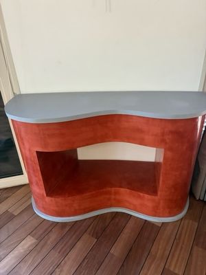une console rouge et grise dans un salon, à côté d'un canapé