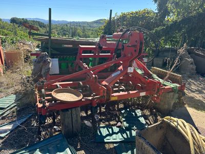 un tracteur rouge qui est garé dans la terre