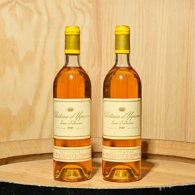 two bottles of wine sitting on top of a barrel
