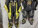 three motorcycle leathers are lined up on a table in front of a white backdrop