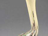 a close up of a glass bird on a gray surface