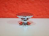 a close up of a metal knob on a white table