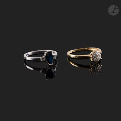 two gold and silver rings with a heart shaped sapphire stone