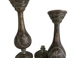 two metal vases sitting next to each other on a white surface