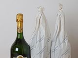 three bags of wine and a bottle of wine on a table