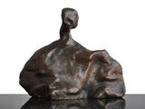 une sculpture en bronze représentant un oiseau perché sur un rocher