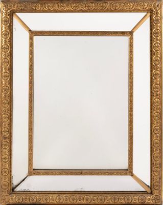 un miroir encadré d'or sur un mur blanc avec un fond blanc