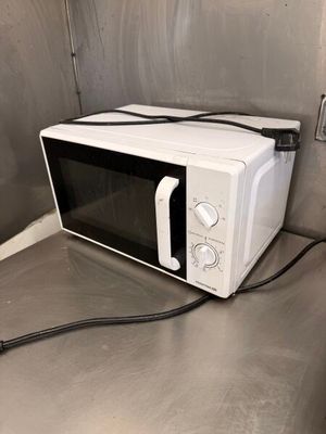 un micro-ondes posé sur le plan de travail de la cuisine