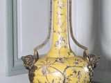 un vase jaune posé sur une table dans une pièce