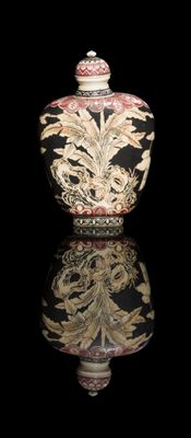 a black and white vase with a gold design on it