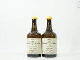 deux bouteilles de vin posées l'une à côté de l'autre sur une surface blanche
