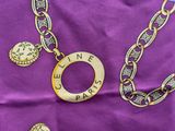 an image of a purple scarf with a gold chain and a necklace with the word celine paris on it