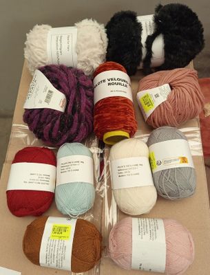de nombreuses pelotes de laine posées sur une boîte en carton