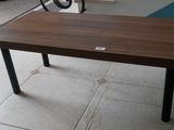 une table en bois aux pieds noirs posée sur un sol carrelé