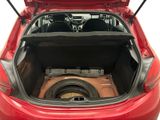 the back of a red car with a sub in the trunk