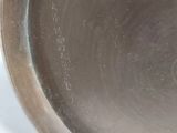 a metal pan with a spoon in it on a white surface