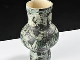 a black and white vase sitting on a white surface