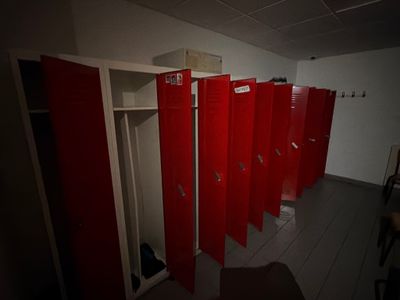 Plusieurs casiers rouges sont alignés les uns à côté des autres dans une pièce