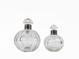 pair of clear glass perfume bottles on a white background