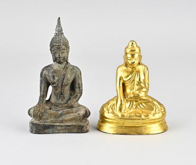 une paire de figurines de Bouddha en or et en argent sur fond blanc