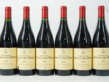six bouteilles de vin rouge sont alignées sur une table