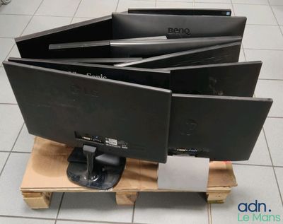 trois écrans d'ordinateur posés sur une palette au sol