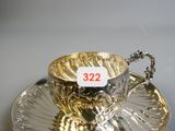 a silver tea cup and saucer on a saucer