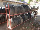 many tires stacked up on a rack in the yard