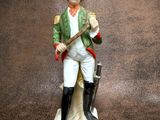 a figurine of a man with a gun on a table