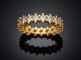 a yellow gold ring with diamonds on a black background