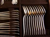 un lot de cuillères et fourchettes en argent dans une boîte
