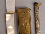 a lighter, a lighter case, and a knife on a table