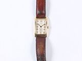 a close up of a watch on a white surface with a white background