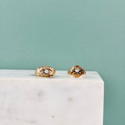 une paire de boucles d'oreilles en or posée sur un bloc de marbre