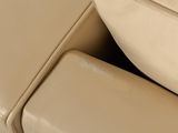 a close up of a beige leather couch with a foot rest