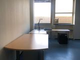 une longue table au milieu d'une pièce dotée de deux fenêtres