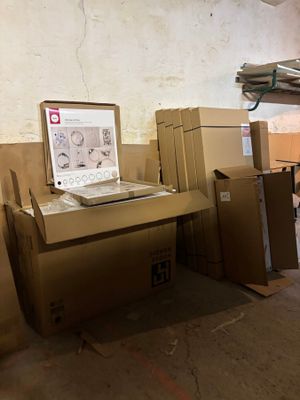 un ordinateur portable posé sur un bureau, entouré de cartons