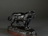 a bronze statue of a dog standing on a wooden base