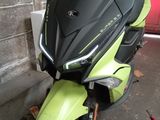 a yellow and black scooter parked next to a red door