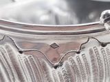 a silver bowl with a handle on a table