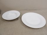 two white plates sitting on a table next to each other