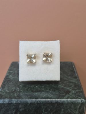 une paire de boucles d'oreilles posée sur un bloc de marbre