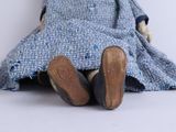 a teddy bear that is wearing a blue dress and shoes