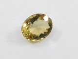 a yellow sapphire stone on a white surface