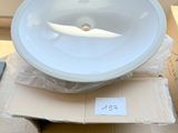 a white bowl sitting on top of a box next to a window